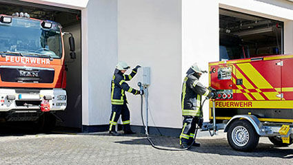 Feuerwehrleute schließen Notstromsteckvorrichtungen an