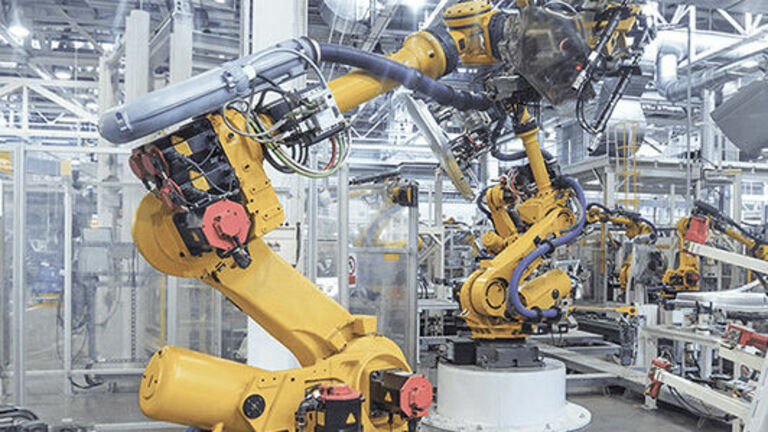 ein gelber Industrieroboter in einer Industriehalle