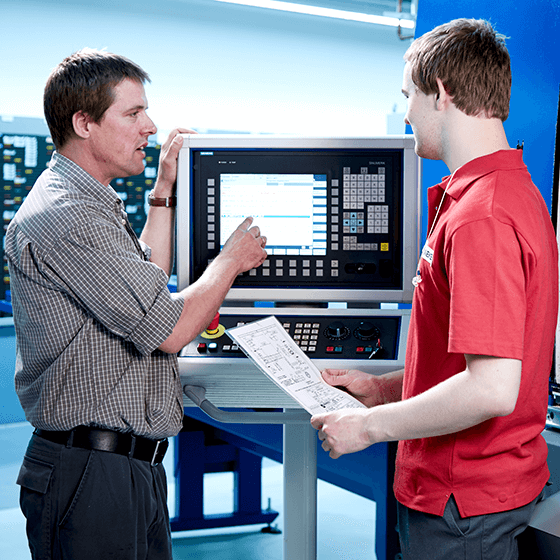 Zwei Personen an einem Maschinendisplay