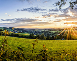 Landschaft im Erzgebirge mit Dorf und Sonnenuntergang