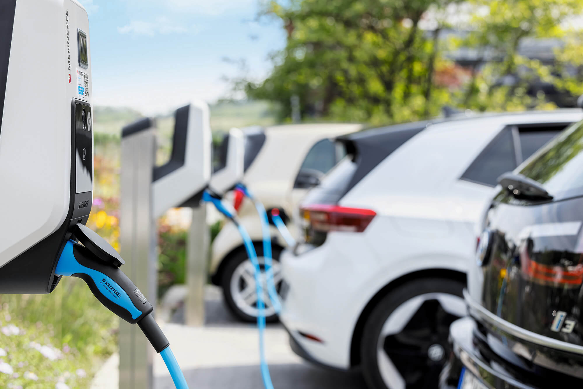 E-Autos laden an Wallboxen auf dem Parkplatz eines Unternehmens