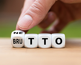 Hand dreht einen Würfel und ändert das Wort "Brutto" in "Netto