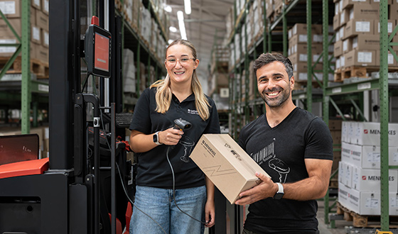 Fachlagerist Zwei Auszubildende in der Lagerlogistik scannen und kommissionieren Waren in einem modernen Hochregallager.