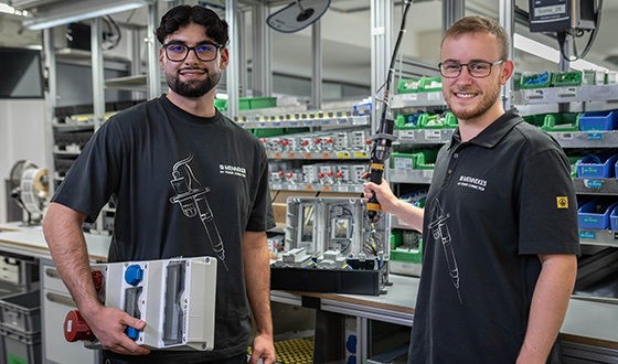 Zwei angehende Industrieelektriker arbeiten an der Installation und Verkabelung von elektrischen Baugruppen.