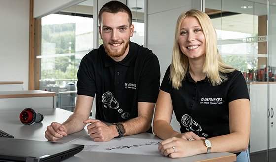 Zwei Auszubildende im Bereich technisches Produktdesign arbeiten gemeinsam an Konstruktionsunterlagen im Büro.