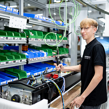 Zwei Personen stehen an einer offenen Ladesäule und verkabeln die Elektrik