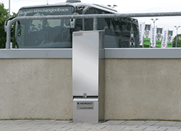 Eine silberne, freistehende CombiTOWER® Steckdosenkombination aus Edelstahl steht vor einem Gelände