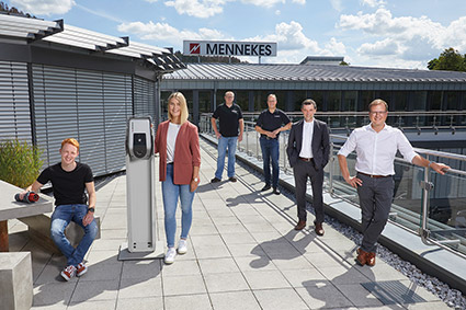 Sechs Personen stehen in Abstand zueinander auf der Dachterrasse. Im Hintergrund ist das MENNEKES Schild zu sehen.