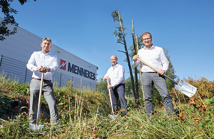 Drei Männer stehen vor der Fabrikhalle von MENNEKES und halten jeweils einen Spaten in der Hand