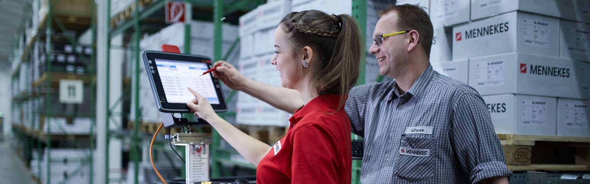 Zwei Personen schauen auf einen Display einer elektrischen Ameise im Lager