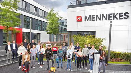 Gruppenaufnahme der neue Azubis mit der Geschäftsführung von MENNEKES vor dem Bürogebäude von MENNEKES