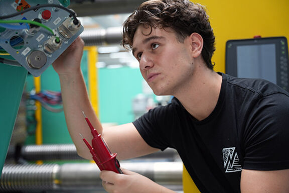 Mechatroniker in Ausbildung arbeitet an einer Maschine