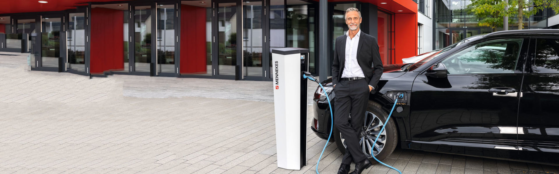 Geschäftsmann lädt sein E-Auto an einer MENNEKES Ladesäule