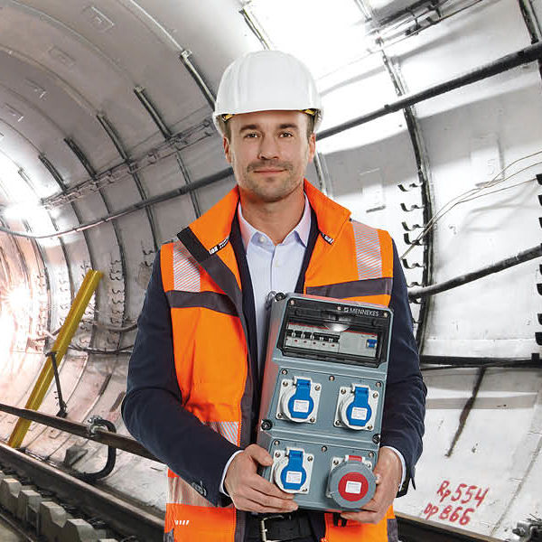 Ein Mann steht in einem Tunnel und hält eine AMAXX Kombination in den Händen