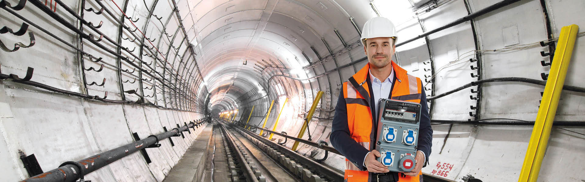 Ein Mann steht in einem Tunnel und hält eine AMAXX Kombination in den Händen