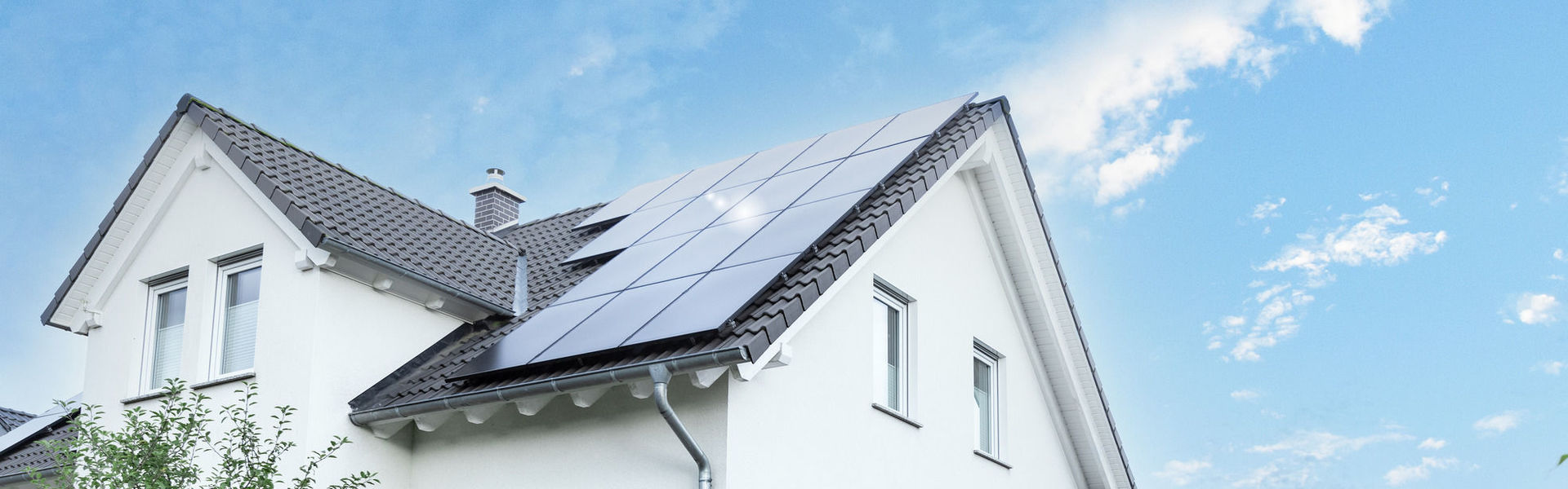 Haus mit Solaranlage auf dem Dach und Wallbox in der Garage