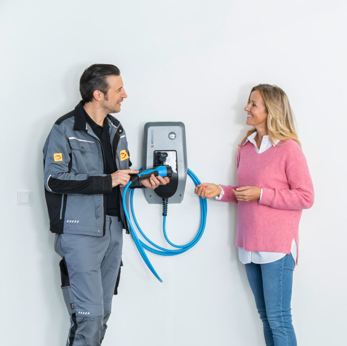 Installateur berät eine Kundin zur Handhabung einer Wallbox