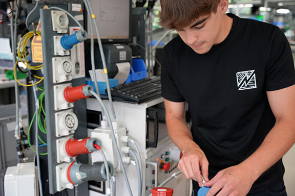 Ein Auszubildener für Industrieelektronik bei MENNEKES arbeitet an Maschinen