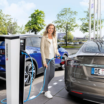 Frau lädt ihr E-Auto an einer MENNEKES Ladesäule