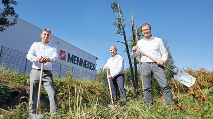 Drei Männer stehen vor der Fabrikhalle von MENNEKES und halten jeweils einen Spaten in der Hand