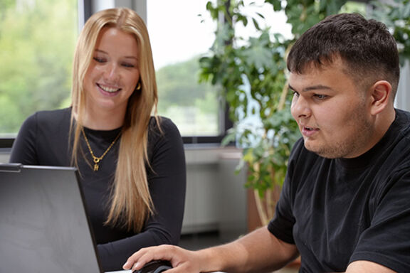 Eine Auszubildende zur Industriekauffrau und ein Auszubildener zum Industriekaufmann bei MENNEKES arbeiten am Computer